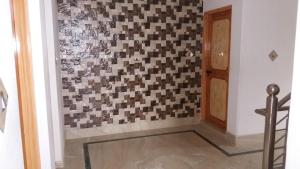 a hallway with a checkerboard pattern on the wall at Al-Bilad Guest House in Srinagar