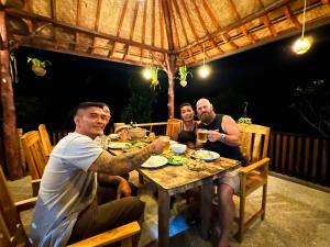 eine Gruppe von Menschen, die mit Getränken am Tisch sitzen in der Unterkunft Artomoro Bali in Munduk