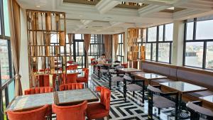 a restaurant with tables and chairs and windows at Minerva Premium Hotel in Hanoi
