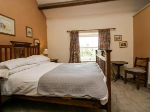 un dormitorio con una cama y una ventana en Moss Side Farm Cottage, en lower hawthwaite