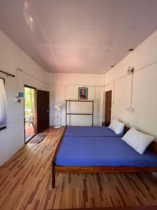 a bedroom with a blue bed in a room at Tranquilandia in Varagampadi