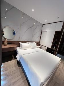 1 cama blanca grande en una habitación con espejo en Apec Mandala Whynham Phu yen- Q House, en Tuy Hoa