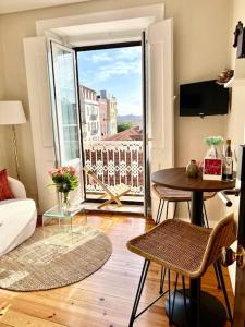 a living room with a table and a large window at Stylish City Apartment - Top Stay! in Lisbon