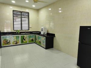 a kitchen with a counter and a refrigerator at Ankanghomestay in Alor Setar
