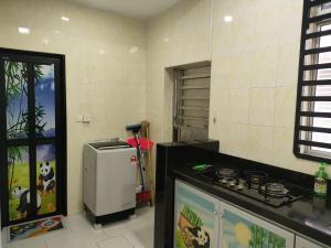 a kitchen with a stove and a refrigerator at ankang in Alor Setar