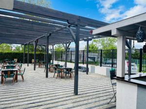 a wooden deck with tables and chairs at Perla in Costinesti