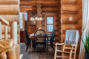 een eetkamer in een blokhut met een tafel en stoelen bij Fiddler Lake Resort Chalet 10 Ours in Mille-Isles