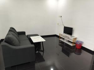 a living room with a couch and a table at Ankanghomestay in Alor Setar