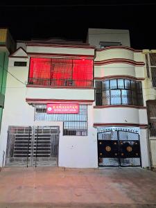 a white building with a red sign on it at Ramayanam Paying Guest House in Ayodhya
