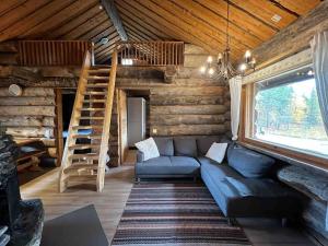 a living room with a blue couch in a log cabin at Keloparitalon loma-asunto Ylläs-näkymällä ja paljulla in Ylläsjärvi