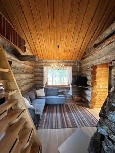 a living room with a blue couch in a log cabin at Keloparitalon loma-asunto Ylläs-näkymällä ja paljulla in Ylläsjärvi