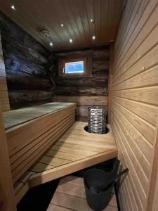 a small wooden sauna with a small window in it at Keloparitalon loma-asunto Ylläs-näkymällä ja paljulla in Ylläsjärvi