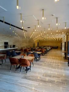 un comedor con mesas, sillas y luces en Amorium Hotel, en Kastamonu