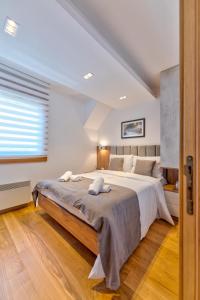 ein Schlafzimmer mit einem großen Bett und einem Fenster in der Unterkunft Vila Pino Silvestre in Zlatibor