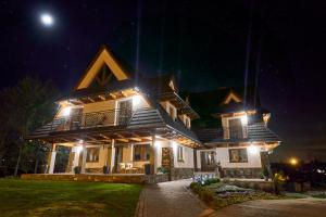 duży dom z oświetleniem w nocy w obiekcie Kohutówka Wynajem Pokoi w Bukowinie Tatrzańskiej