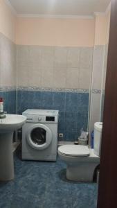 La salle de bains est pourvue de toilettes, d'un lavabo et d'un lave-linge. dans l'établissement Horizon, à Bishkek