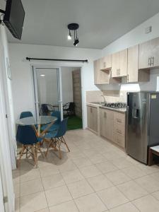 a kitchen with a table and chairs and a refrigerator at MINI CASA ECOTERRA SANTA ANA in Santa Ana