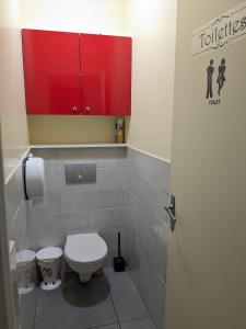La salle de bains est pourvue de toilettes et d'une armoire rouge. dans l'établissement Chambre double simple en face de la gare, à Roanne