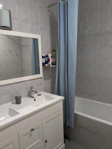 La salle de bains est pourvue d'un lavabo et d'une douche avec un miroir. dans l'établissement Chambre double simple en face de la gare, à Roanne
