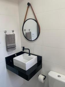 ein Badezimmer mit einem weißen Waschbecken und einem Spiegel in der Unterkunft Apartamento em Santos na Ponta da Praia in Santos