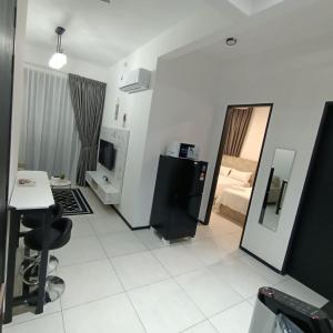 a living room with a desk and a television in a room at Urban Suites Jsw in Jelutong