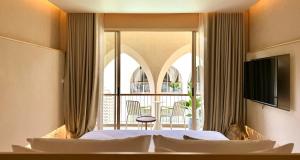 a hotel room with a bed and a balcony at Navakiri Boutique Resort Satun in Ban Khuan