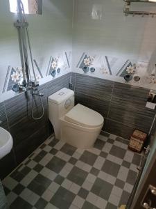 a bathroom with a toilet and a checkered floor at Blue home in Mù Cang Chải