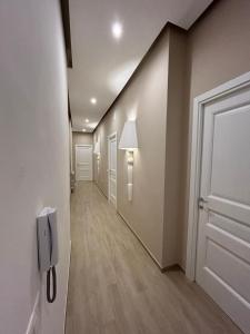 un pasillo con una puerta blanca y un pasillo con una lámpara en BED e SUITE DOMAR, en Brindisi