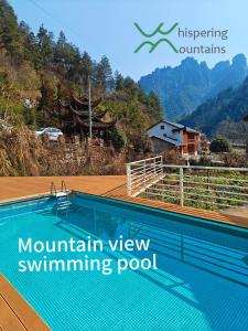een zwembad met uitzicht op de bergen bij Whispering Mountains Boutique Hotel in Zhangjiajie