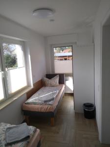 ein kleines Zimmer mit einem Bett und zwei Fenstern in der Unterkunft Großes Haus in Zossen
