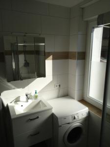 a bathroom with a sink and a washing machine at Großes Haus in Zossen +18 photos