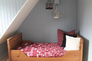 um pequeno quarto com uma cama e uma escada em Casa Angres - Lüneburger Heide 