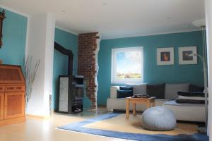 uma sala de estar com um sofá e uma lareira em Casa Angres - Lüneburger Heide 