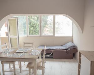 een eetkamer met een tafel en een bank bij Aleksapart in Boergas