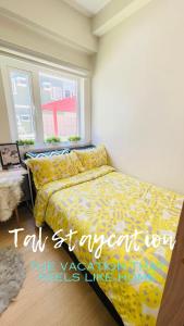 una camera con letto e copriletto giallo di TAL Staycation 1 Bedroom 1 Bathroom & Kitchen ,Neflix,up to 300 to 400 mbps high speed internet cozy,spacious,accessible new condo unit at SMDC Trees Residence Quezon City a Manila