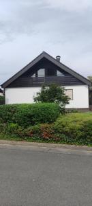 ein weißes Haus mit schwarzem Dach auf einer Straße in der Unterkunft House Garden close to Frankfurt Airport in Groß-Gerau