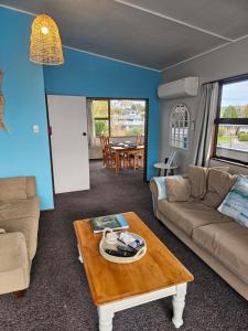 uma sala de estar com um sofá e uma mesa em Catlins area accommodation em Owaka