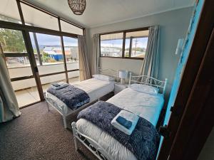 two beds in a room with a window at Catlins area accommodation in Owaka