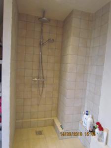 y baño alicatado con ducha y cabezal de ducha. en Køge Bed & Kitchen - Rooms, en Køge