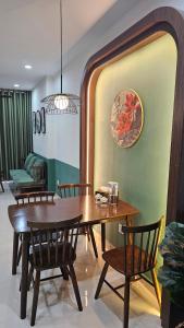 a dining room with a wooden table and chairs at Happy House Quy Nhơn in Quy Nhon