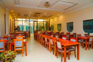 une salle à manger avec des tables et des chaises en bois dans l'établissement Tilko City Hotel Jaffna, à Jaffna