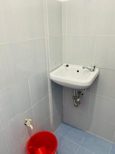 een badkamer met een wastafel en een rood toilet bij Romblon Transient House 2nd Floor in Romblon