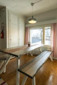 a dining room table with a bench in front of a window at Kalle's unluxury guest house Aircon 15min city center by train in Helsinki