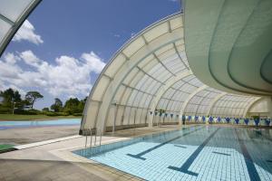 a swimming pool in a building with a ceiling at Satsuma Resort Hotel in Satsuma