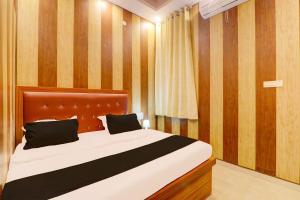 1 dormitorio con 1 cama grande y cabecero de madera en OYO Shobhika Inn, en Lucknow