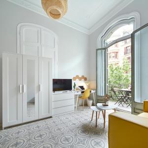 a living room with a large window and a tv at GIRONA in Barcelona