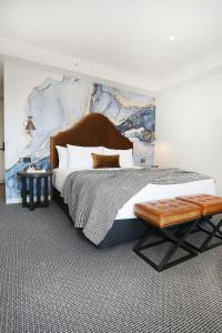 a bedroom with a large bed with a large wall at Lake Jindabyne Hotel in Jindabyne