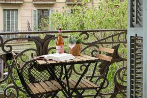 uma mesa com uma garrafa de vinho e um livro em GIRONA em Barcelona