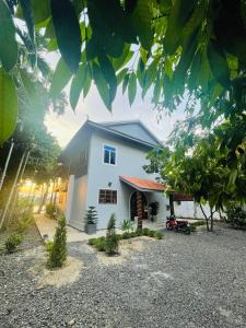 a white house with a driveway in front of it at HOLY VILLA 4rooms, 5beds, 6baths, 1KCH, 1LR riverside private villa in Kampot