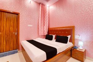 1 dormitorio con 1 cama grande en una habitación rosa en OYO Shobhika Inn, en Lucknow
